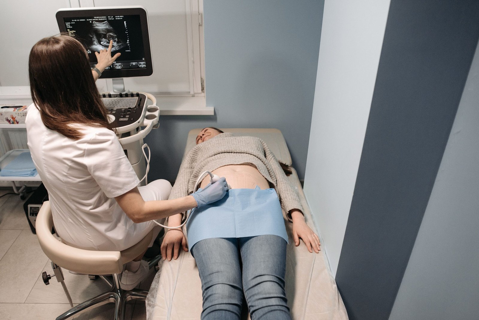 About Healthcare professional performing an ultrasound scan on a patient in a medical clinic.